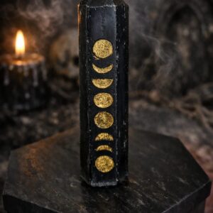 Bougie triple lune noire avec symboles lunaires dorés dans une ambiance gothique et ésotérique